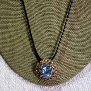 Goldtone blue crystal pendant on black cord necklace